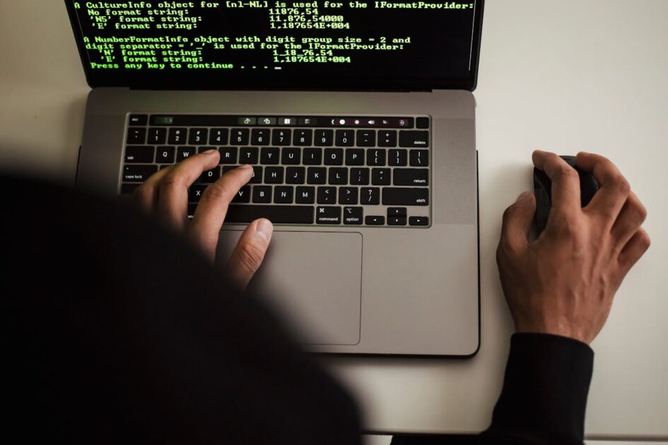 Crop faceless programmer working on laptop in studio