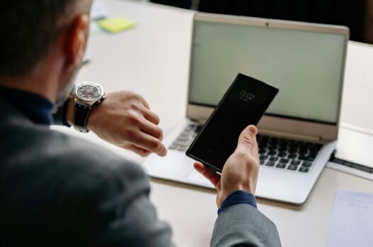 Man Looking at the Time While Holding a Phone